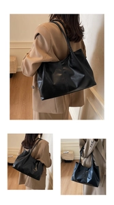 Detail view of a large black faux leather tote bag with a sleek glossy finish for women