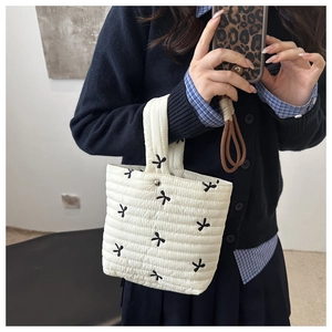 Vista dettagliata della borsa tote trapuntata bianca con ricami di farfalle nere