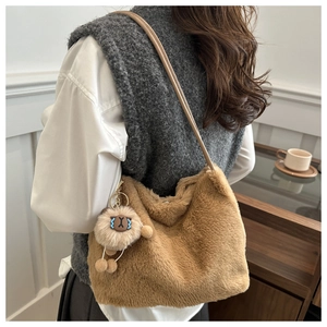 Close-up of brown plush shoulder bag with cute alpaca charm and leather strap