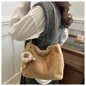 Detail of brown plush crossbody bag featuring a soft sheep charm and leather strap