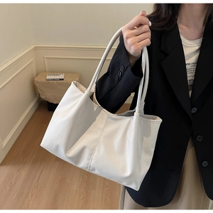 Detailed close-up of large white tote bag with soft PU leather texture and shoulder strap