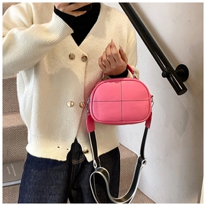 Detail of pink lychee leather pillow bag with cross-stitch design and wide strap