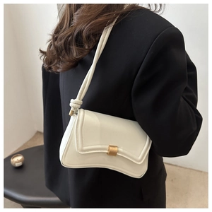 Detailed side view of a white minimalist shoulder bag with a gold metal buckle on a model