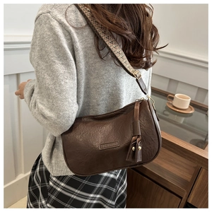 Detail of lychee pattern leather shoulder bag with wide geometric woven strap