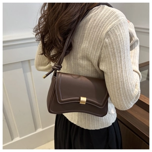 Minimalist dark brown baguette bag with gold buckle and knotted shoulder strap detail