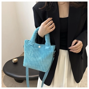 Light blue corduroy bucket bag texture and shoulder strap attachment details