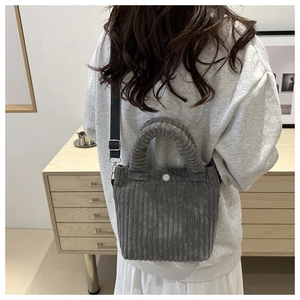 Detail view of dark grey corduroy tote bag with plush handle and nylon strap