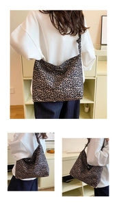 Detail of leopard print canvas hobo bag with wide shoulder strap shown on model