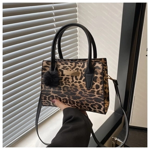 Détails du sac à main léopard avec doubles poignées noires et pompon décoratif chic