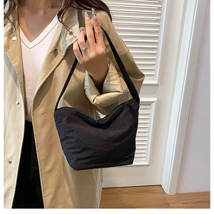 Détail d'un sac cabas plissé noir montrant la texture froissée et la fermeture éclair