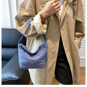 Vue détaillée du sac demi-lune plissé bleu en nylon texturé avec bandoulière large