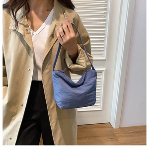 Gros plan du sac hobo plissé bleu Morandi avec tissu texturé et fermeture éclair