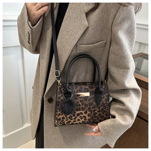 Détail du sac à main imprimé léopard avec pompon noir et garniture dorée chic
