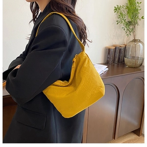 Vue détaillée du sac seau plissé jaune vif en toile avec une large bandoulière