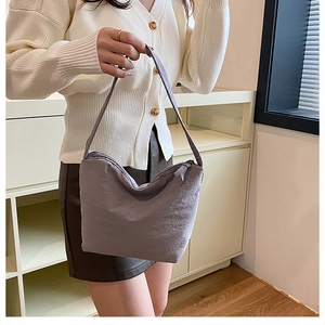 Détail du sac hobo en nylon plissé gris-mauve montrant la texture et la fermeture éclair