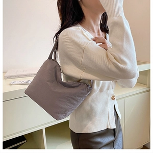 Gros plan d'un sac cabas en tissu plissé gris avec texture douce et style minimaliste