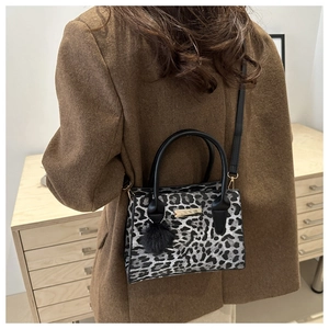 Sac à main léopard avec pompon en fourrure porté avec un blazer marron chic