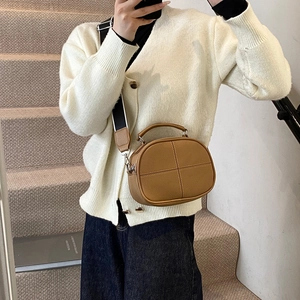 Brown leather crossbody pillow bag with wide striped strap and pebble texture finish