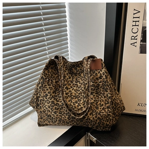 Detail of leopard print canvas tote bag featuring a leather patch and double straps