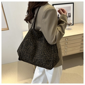 Detailed view of spacious leopard print tote bag styled with a brown blazer for workwear