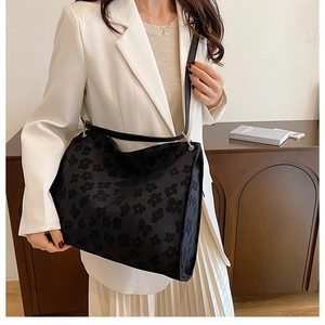 Détail du grand sac cabas noir avec motif jacquard floral et bandoulière en cuir