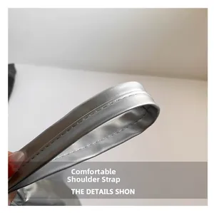 Detail view of the silver metallic shoulder strap with reinforced stitching on the bag