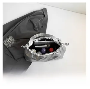 Interior view showing the large capacity of a silver metallic tote bag with daily items