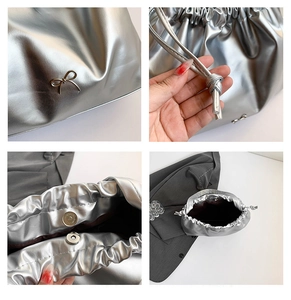 Close-up of silver drawstring cloud bag featuring metal bow and magnetic closure details