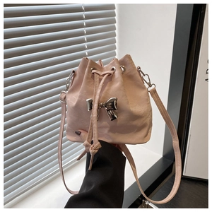 Detail of pink bucket bag featuring a silver metal bow and drawstring closure