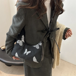 Borsa sottospalla nera con ricami a farfalla e tracolla decorata con fiocco alla moda