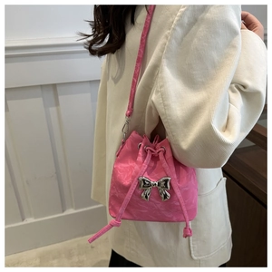 Detail of pink mini bucket bag with silver butterfly buckle and drawstring closure