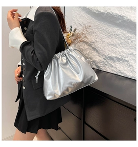 Détail du sac seau métallisé argenté avec des plis et un nœud délicat décoratif