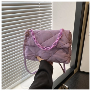 Dettaglio borsa a tracolla in nylon trapuntato viola con catena e finiture dorate