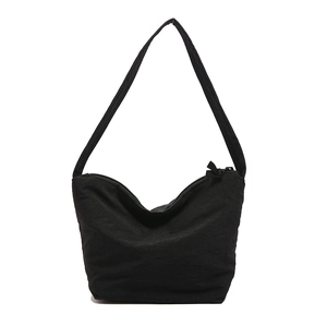 Sac nuage plissé noir minimaliste avec large bandoulière et fermeture éclair sur fond blanc