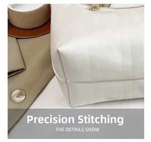 Dettaglio macro delle cuciture di precisione e della texture di una borsa crema