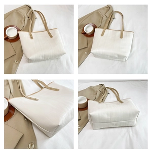 Dettaglio borsa tote color crema con trama verticale, manici e ampio spazio interno