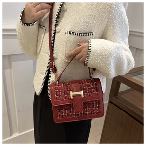 Detail of red tweed handbag featuring a gold buckle lock and premium woven texture