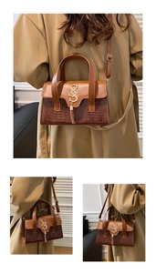 Detail of brown patchwork bag with crocodile texture and gold metal tassel logo