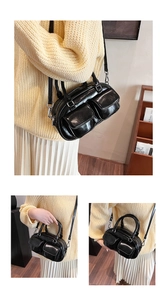 Détail du sac baguette noir brillant avec doubles poches et bandoulière réglable chic