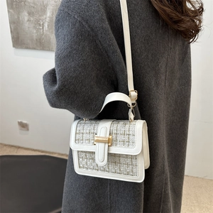 Elegant white tweed and leather handbag with gold hardware shown on model