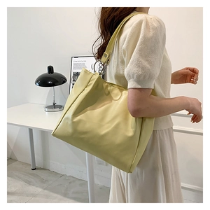 Detail view of large cream tote bag with silver metal ring buckle and minimalist design