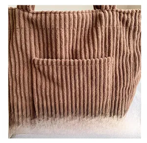Close-up of brown corduroy tote bag with Free color embroidery and front pocket detail