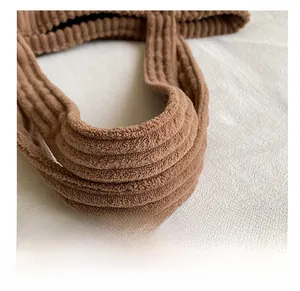 Macro detail of the thickened brown corduroy tote bag handle with soft ribbed texture