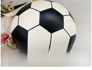 Detail of football-shaped crossbody bag featuring black and white pebble texture leather