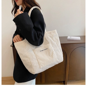 Detail of cream corduroy tote bag showing fine ribbed texture and Free Color embroidery