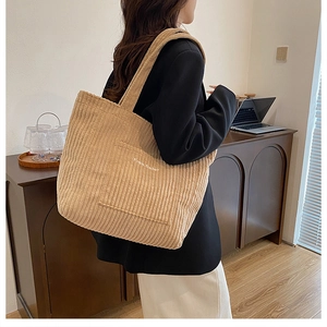 Detailed view of khaki corduroy tote bag with Free Color embroidery on front pocket