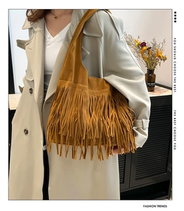 Detail of tan suede tote bag featuring long fringes and bohemian vintage styling