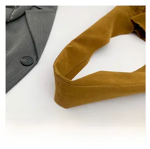 Close-up of wide brown suede shoulder strap with precise stitching on a tote bag
