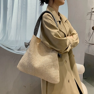 Minimalist straw woven tote bag with houndstooth shoulder strap and beige natural texture
