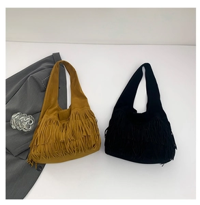 Detailed view of bohemian style tassel tote bags in brown and black suede finish